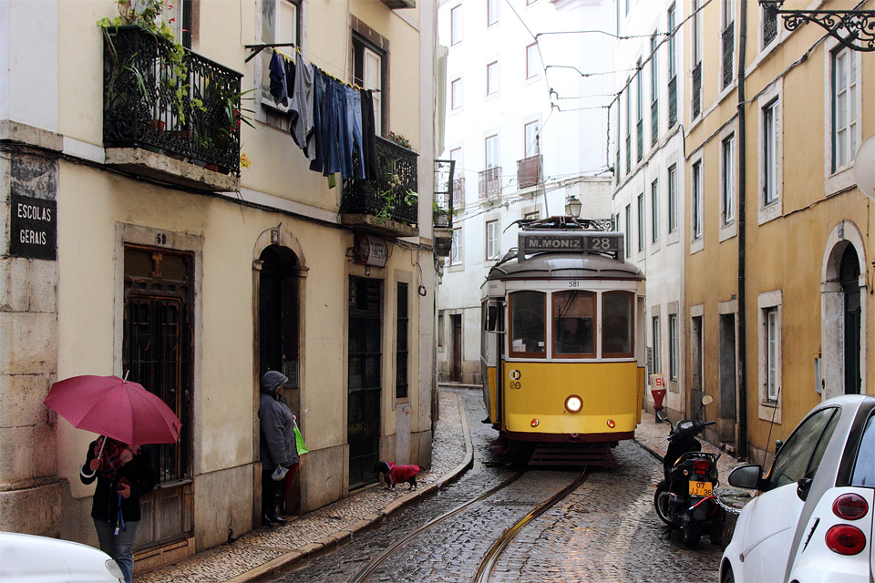 狭い屈曲路を走る路面電車の写真（ポルトガル　リスボン）。